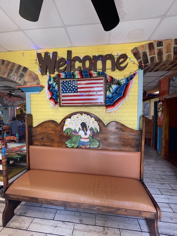 Mexican restaurant interior with tables and warm lighting.